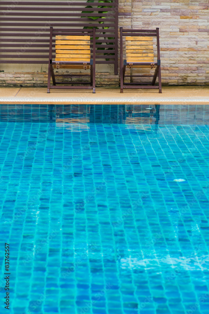 Chair on ground beside swimming pool