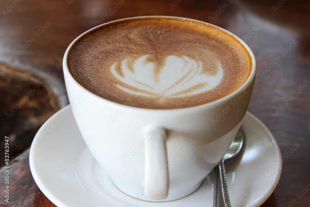Hot cappuccino in white cup on wooden table. Hot cappuccino in white cup on wooden table.