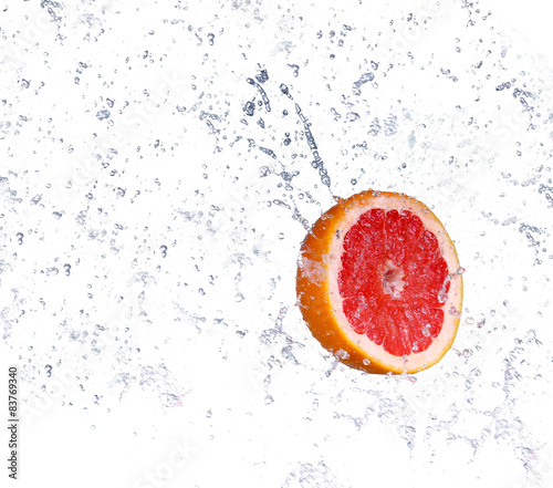 Studio shot of fresh grapefruit with water splash, isolated