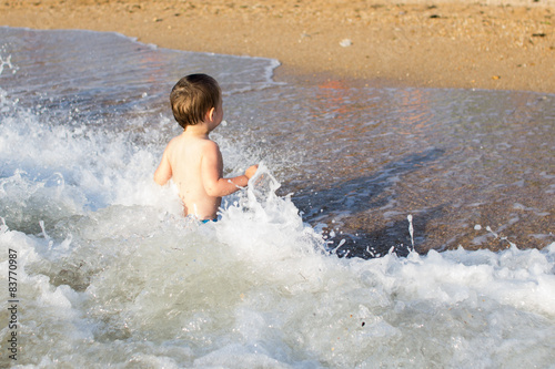 a little boy having fun in the sea on the waves 