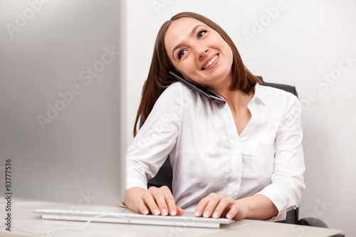 Businesswoman is phoning at her desk