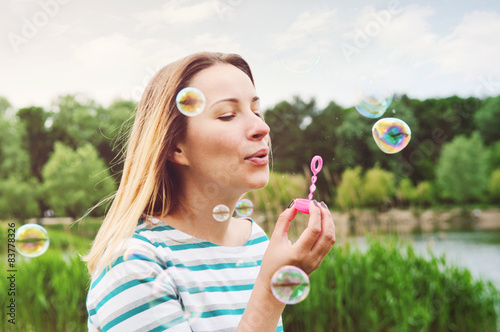 Beautiful girl blowing soap bubbles