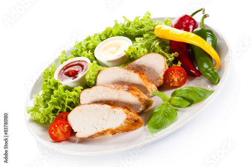Roast chicken fillet and vegetables on white background