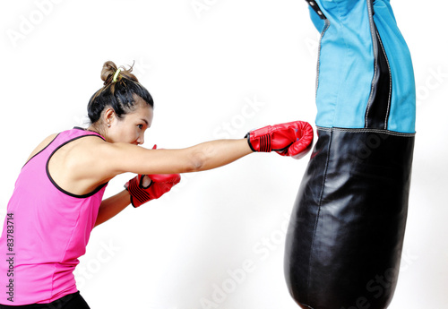 attractive young woman making a punch on the blue sandbag