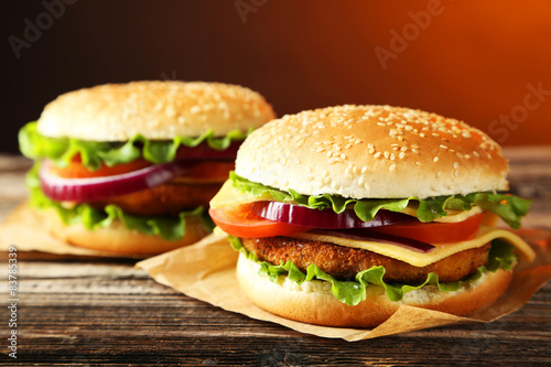 Fresh burgers on brown wooden background