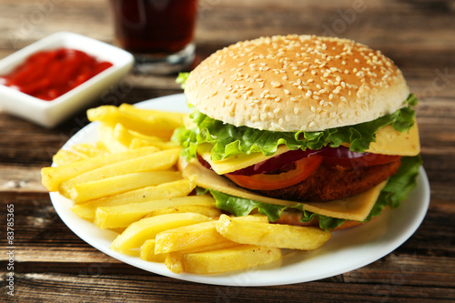 Fresh burger on plate on brown wooden background