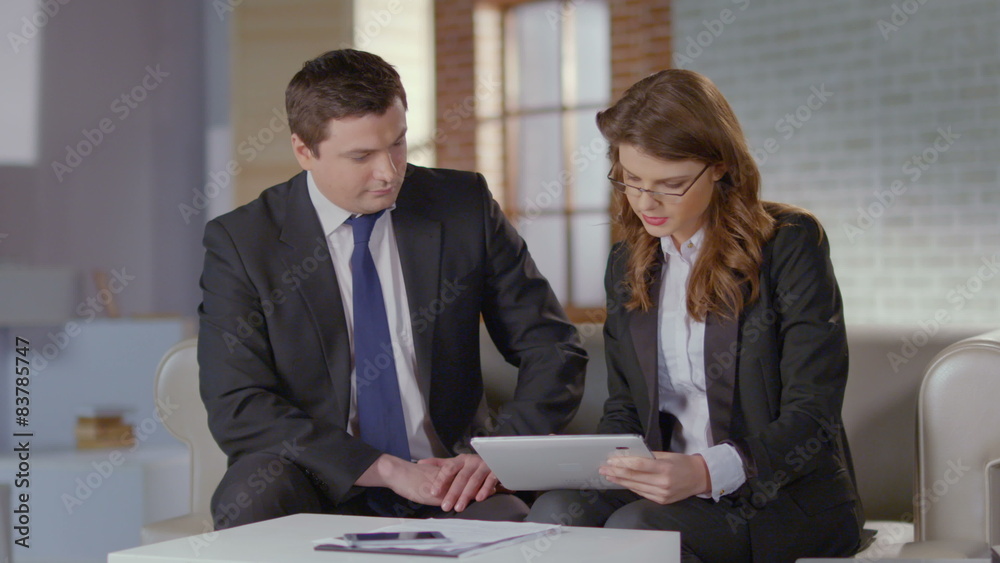 Female employee presenting report on tablet to boss, slow motion Female employee presenting report on tablet to boss, slow motion