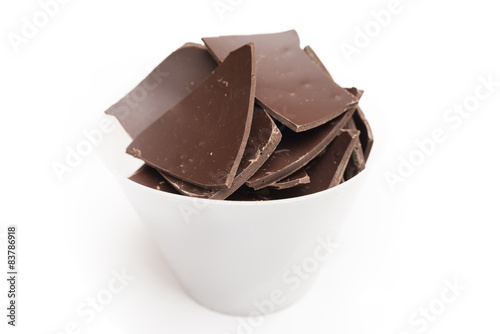Pezzi di cioccolato fondente su sfondo bianco