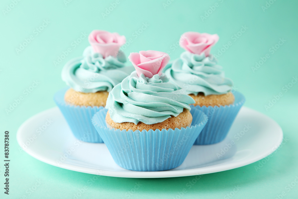 Tasty cupcake on plate on green background