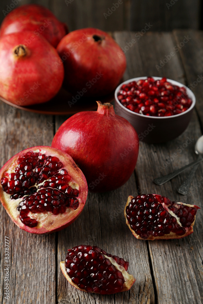 Delicious pomegranate fruit on grey wooden background Delicious pomegranate fruit on grey wooden background