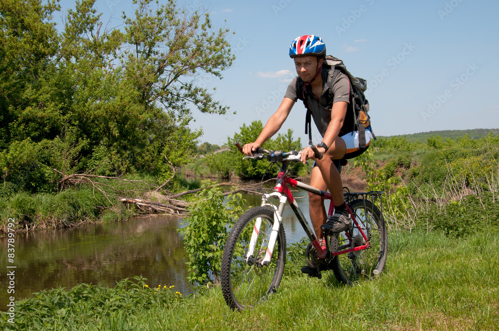 Obraz premium Mountain biker beside a beautiful river