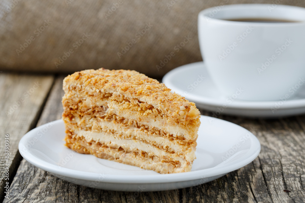 Tasty honey cake with cup of coffee on wooden background. Tasty honey cake with cup of coffee on wooden background.