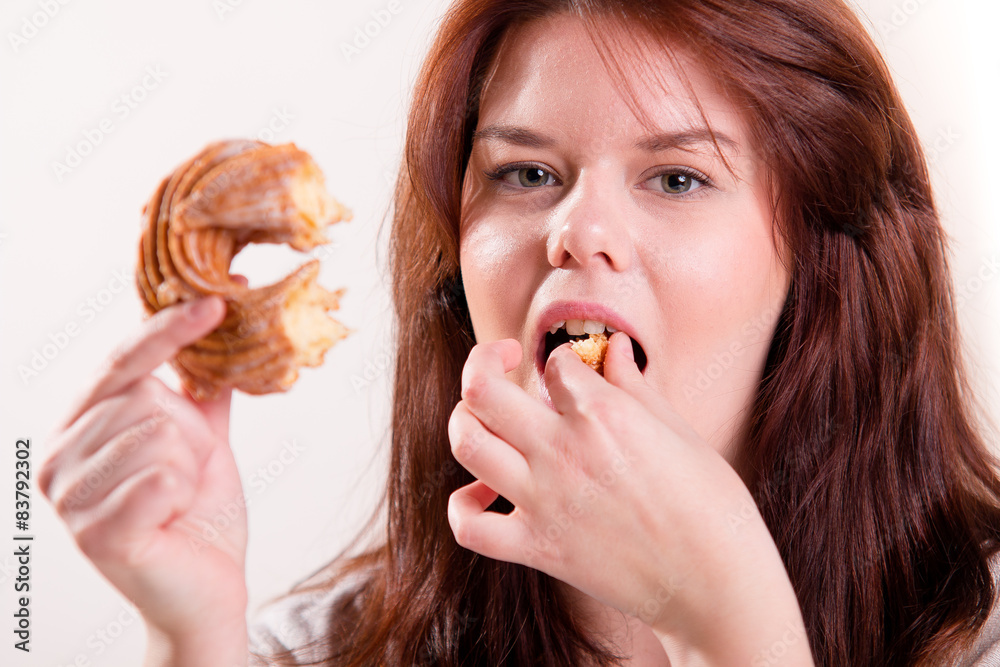 Woman eating a donut using her fingers Woman eating a donut using her fingers