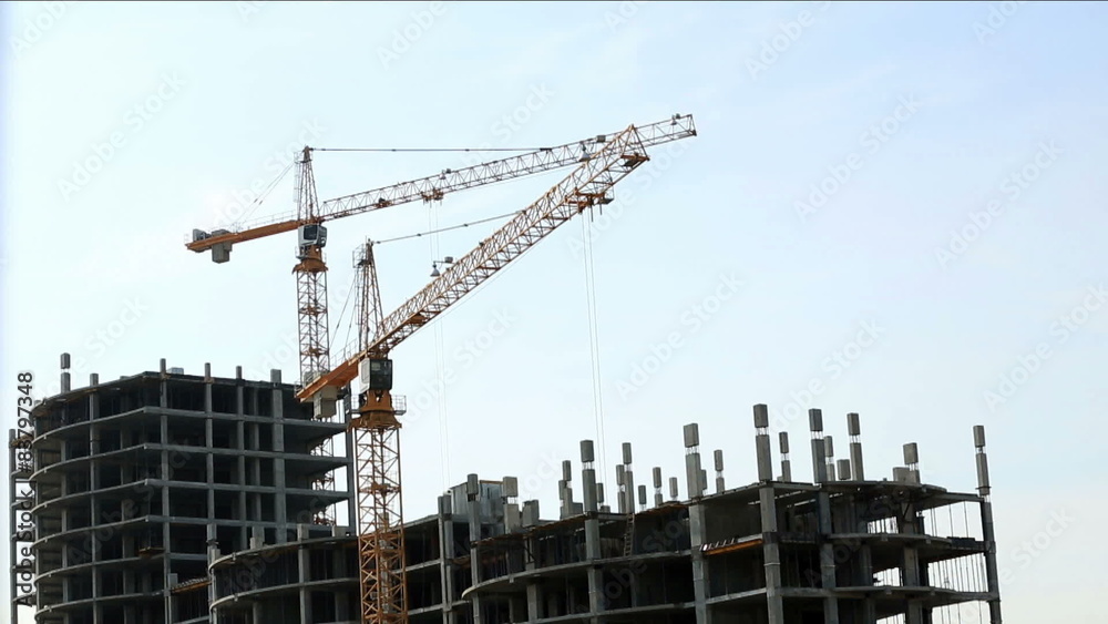 Construction site. View of cranes on sky backdrop Construction site. View of cranes on sky backdrop