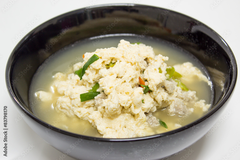 Fried Eggs in Clear Soup in black bowl on white background