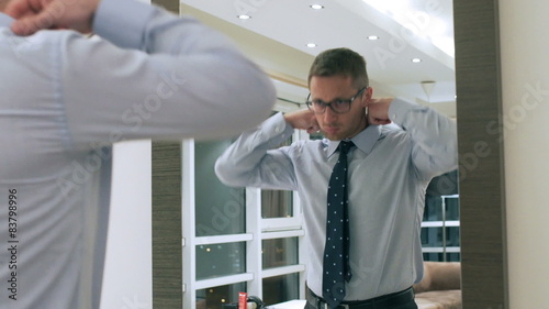 Businessman getting ready in front of the mirror 
