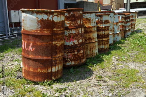 oil drums stacked together in a yard, 