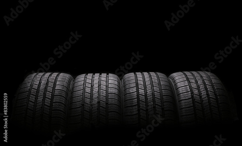 four automobile rubber tires isolated on black background photo