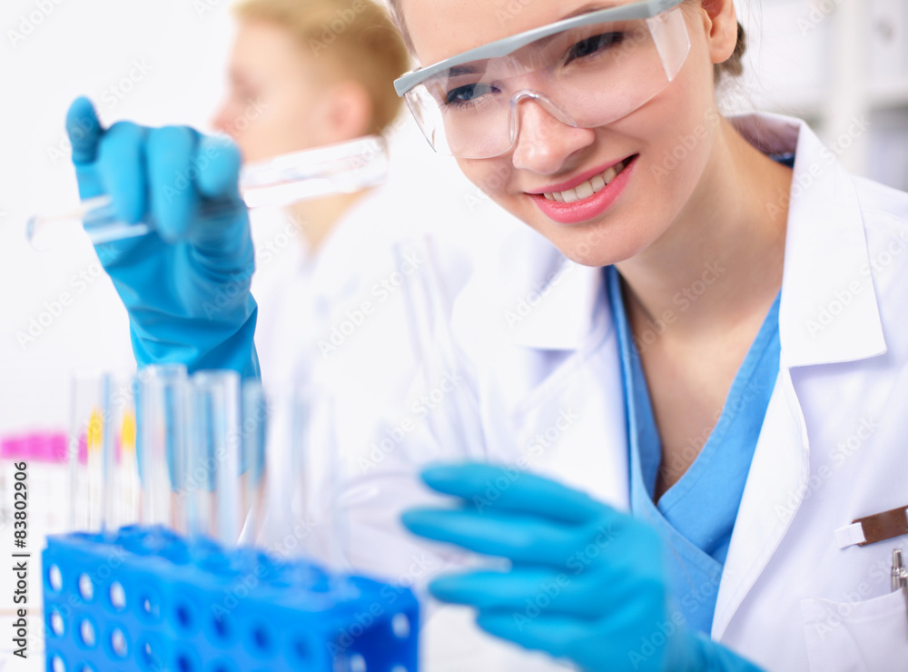 Woman researcher is surrounded by medical vials and flasks Woman researcher is surrounded by medical vials and flasks