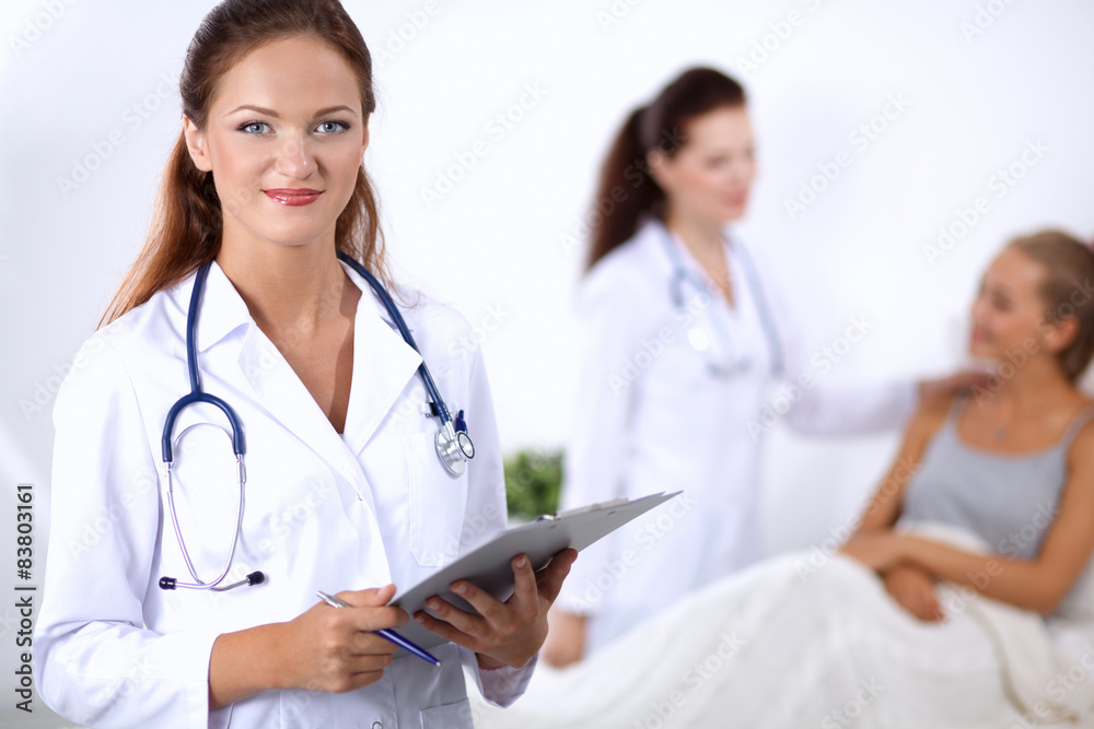 Smiling female doctor with a folder in uniform standing at Smiling female doctor with a folder in uniform standing at