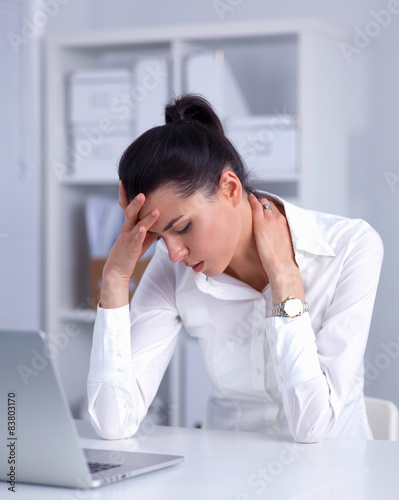 Stressed businesswoman sitting at desk in the office