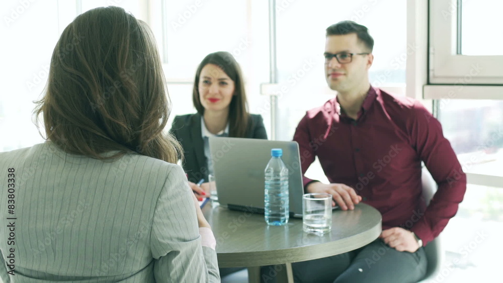 Businesspeople interviewing a woman in the office

