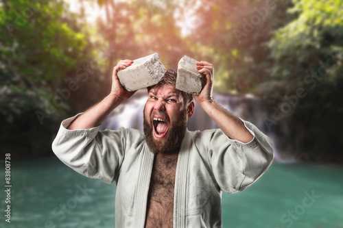 Strong karateka breaks a brick