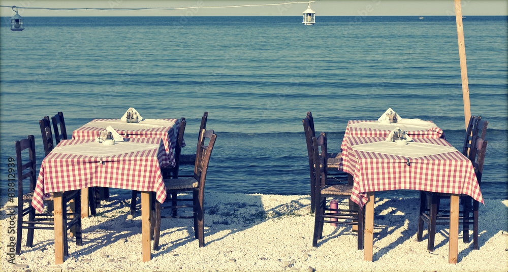 Dining table and chairs on the beach - retro styled photo