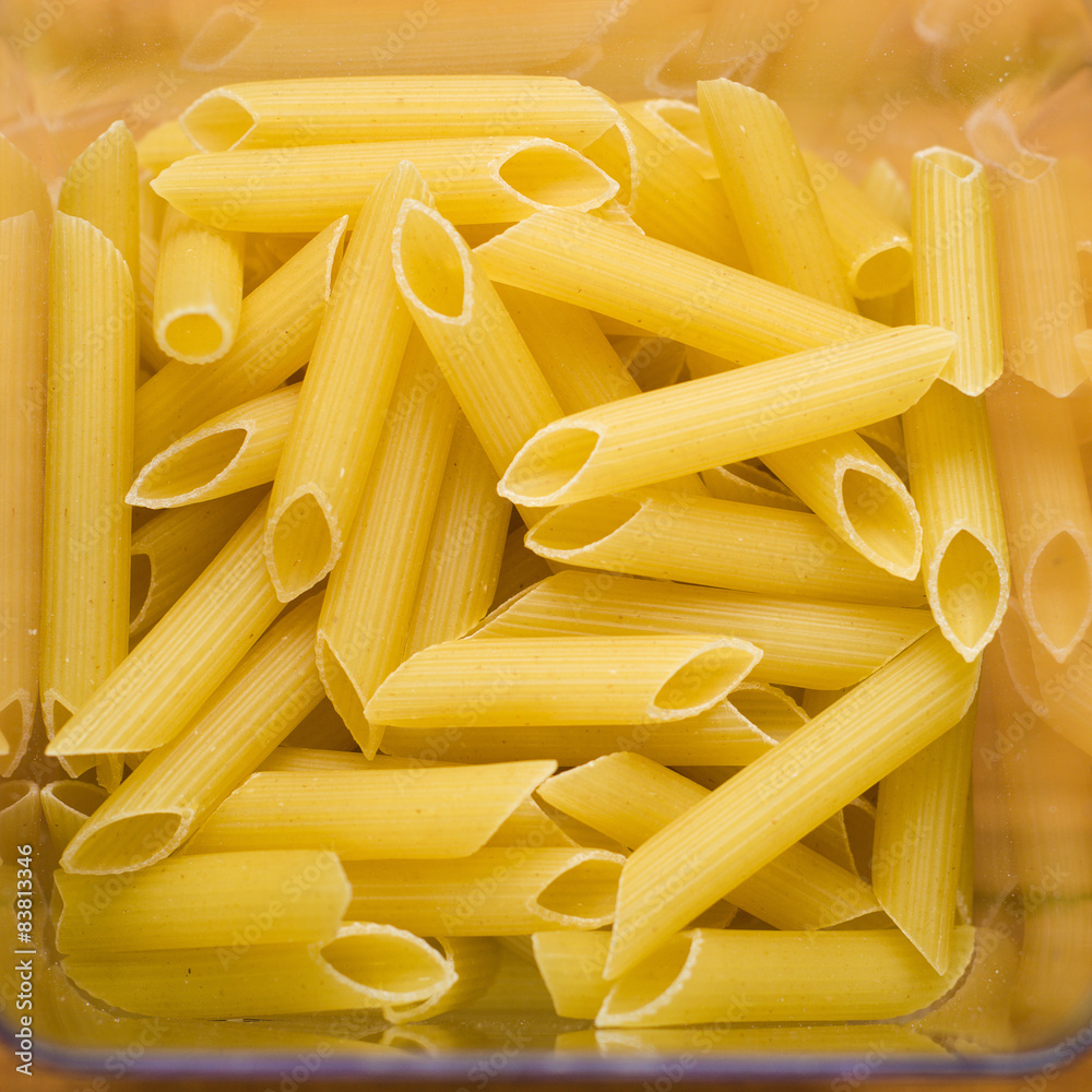 transparent container with uncooked spaghetti on wooden table transparent container with uncooked spaghetti on wooden table