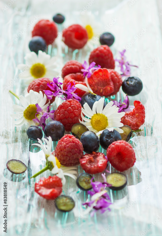 Raspberries and blueberries with summer flowers