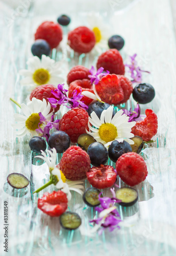 Fototapeta Naklejka Na Ścianę i Meble -  Raspberries and blueberries with summer flowers