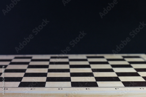 Chess board with chess pawns. Checkerboard black background.