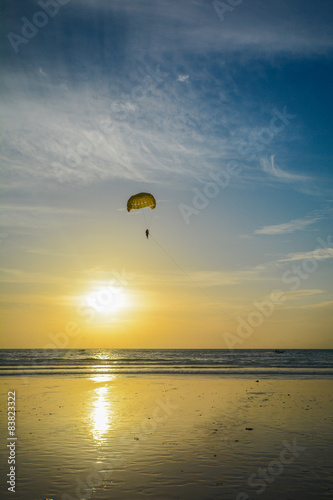 paragliding over the sea in the sunset time