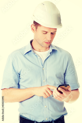 Contractor in hardhat using his cell phone
