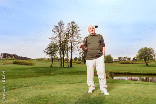 Man on course with golf club at shoulder 