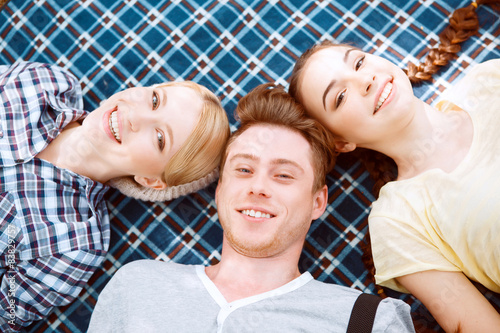 Happy young people lying on cover 