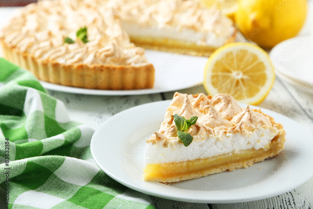 Lemon meringue pie on plate on white wooden background Lemon meringue pie on plate on white wooden background