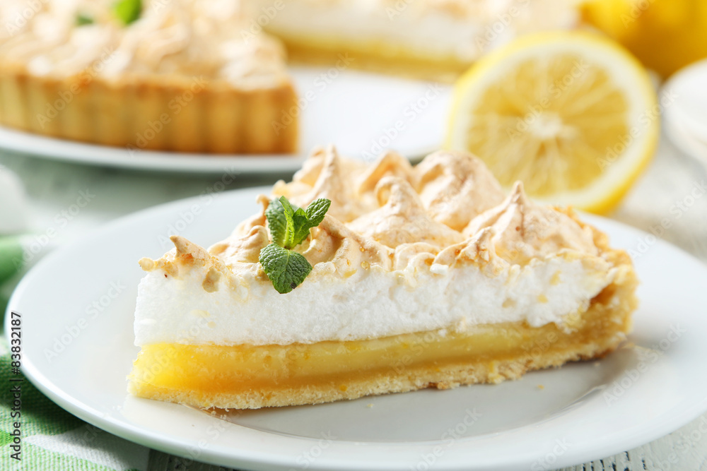 Lemon meringue pie on plate on white wooden background Lemon meringue pie on plate on white wooden background