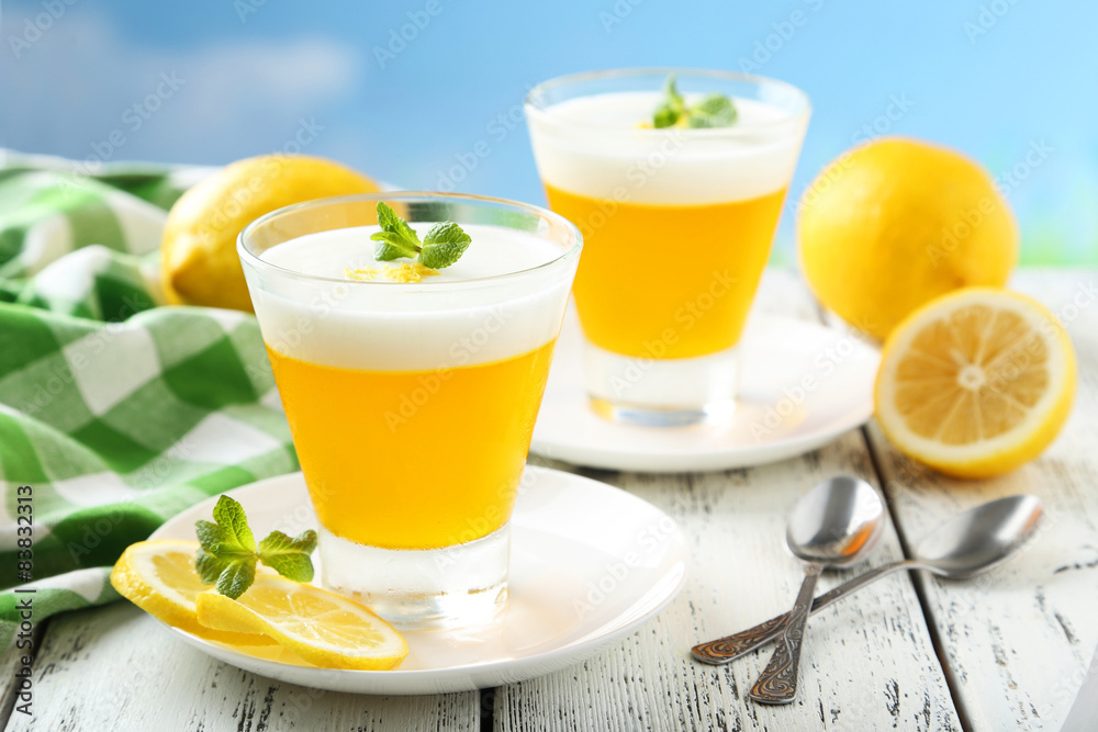 Tasty lemon jelly in glass on white wooden background Tasty lemon jelly in glass on white wooden background