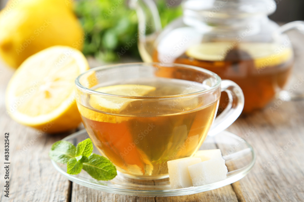 Cup of tea with mint and lemon on grey wooden background Cup of tea with mint and lemon on grey wooden background