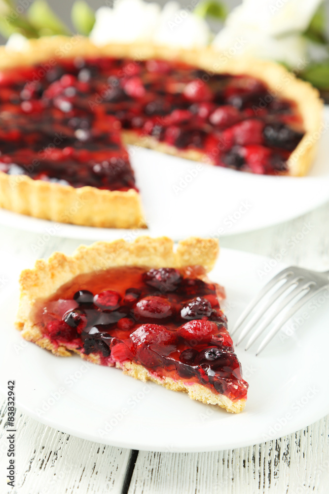 Fresh berry tart on plate on white wooden background Fresh berry tart on plate on white wooden background