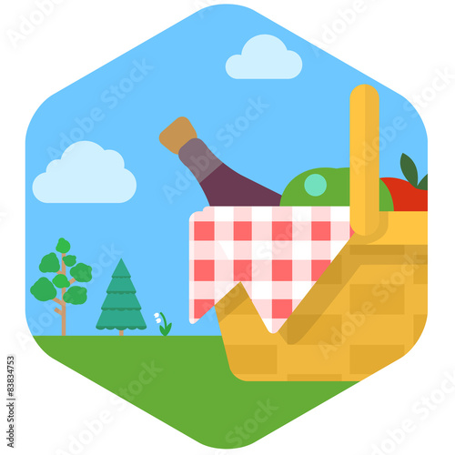 Basket for picnic with wine and fruit against grassy meadow.