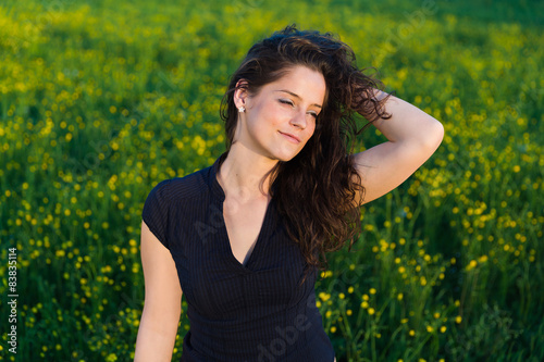 Young beautiful woman with hand in her hair enjoying sunset.