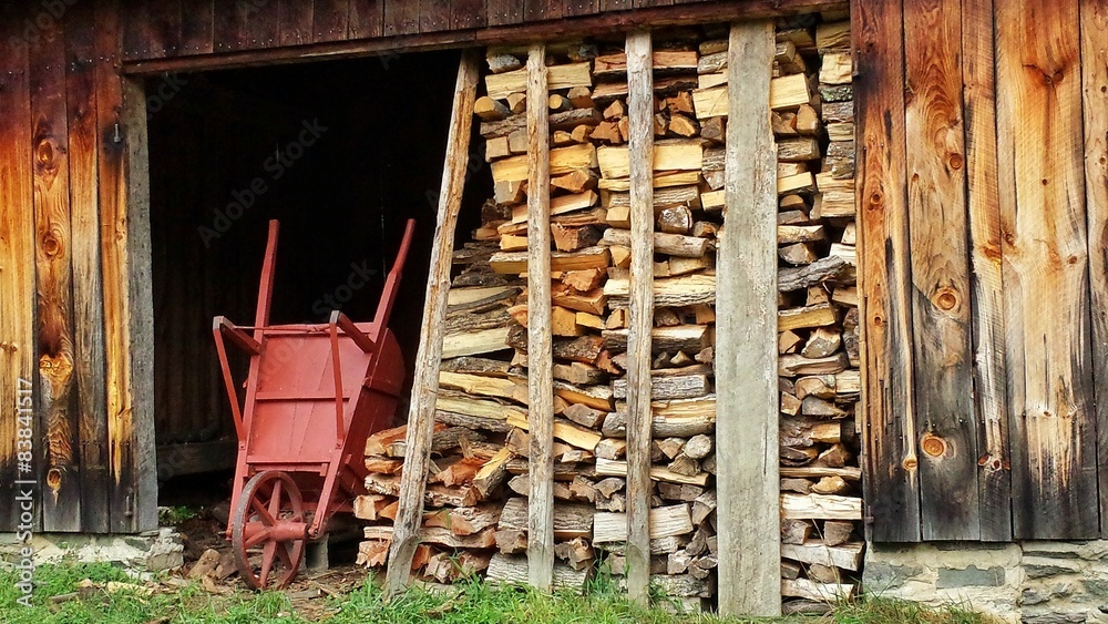 Split Firewood and Wheelbarrow by Old Shed