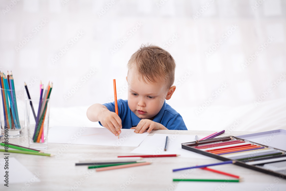 Kleiner Junge malt Bilder mit Buntstiften Kleiner Junge malt Bilder mit Buntstiften