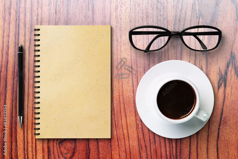 Blank diary and coffee cup on a wooden surface Blank diary and coffee cup on a wooden surface