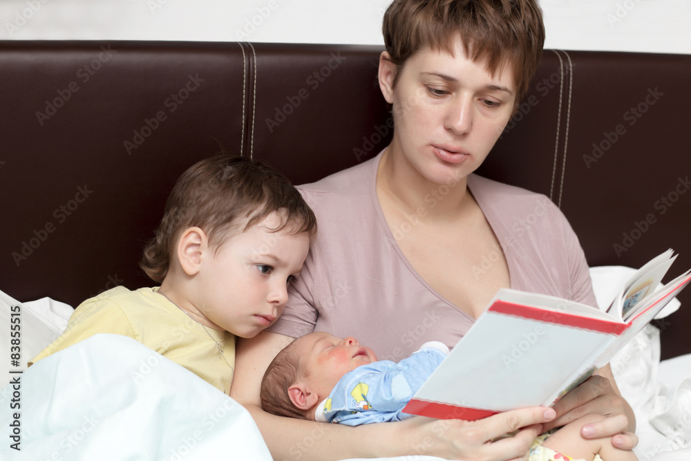 Mother reading book for her sons Mother reading book for her sons
