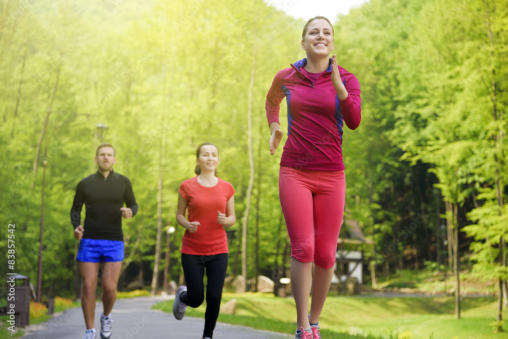 Smiling friends running outdoors. Smiling friends running outdoors.