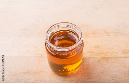 Honey in a mason jar on a wooden background