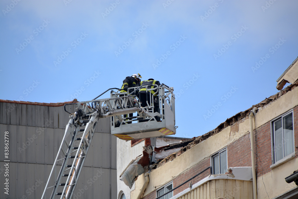 bomberos trabajando en la cornisa de un edificio bomberos trabajando en la cornisa de un edificio